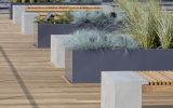 Steel trough planters alternate with benches