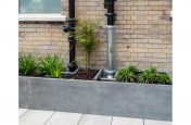Custom shaped planter with drain pipe routing